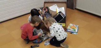 Lapset tutkivat matkalaukkua päiväkodilla.