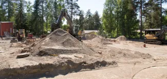 Kaivinkone kaivaa hiekkaa tontilla.