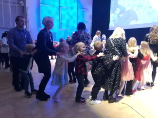 Lapsia ja aikuisia tanssimassa.