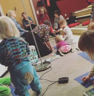 Lapsia ja aikuisia kirjaston satuhuoneessa.