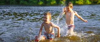 Pojat uimassa järvenrannalla.