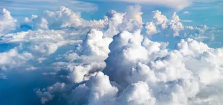 Valkoiset pilvet sinisellä taivaalla.