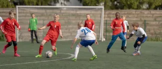 Pojat pelaavat jalkapalloa Keskuskentällä.