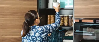 Nainen täyttää 72 tunnin kotivara varastoja arjen häiriöitä varten.