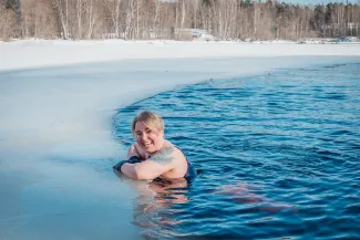 Nainen hymyilee avannon reunalla.